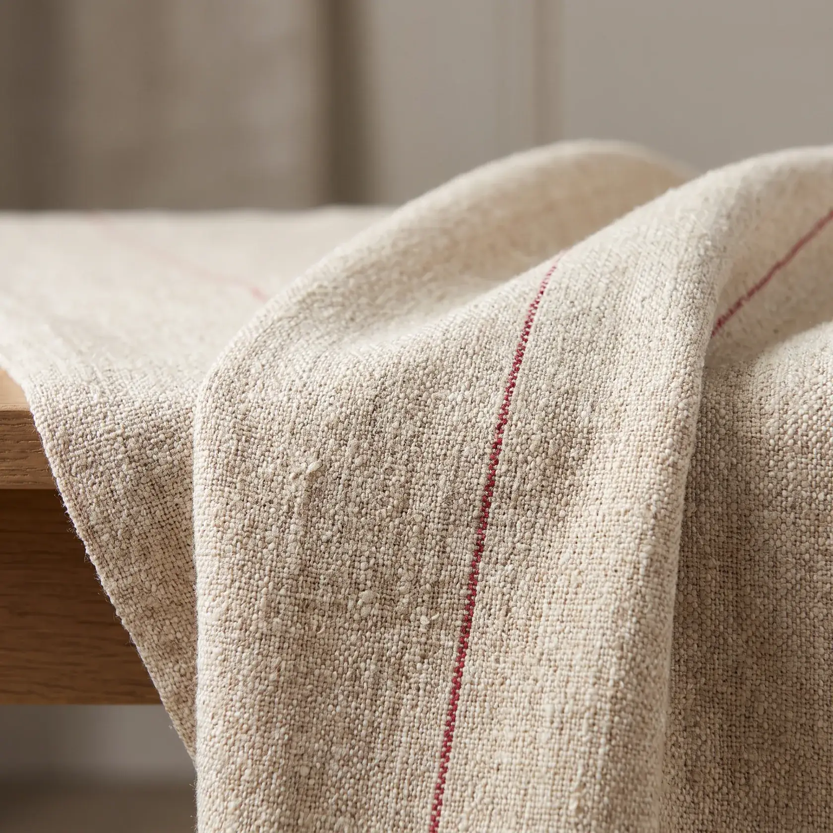 Natural linen-look woven upholstery fabric with a crimson pinstripe